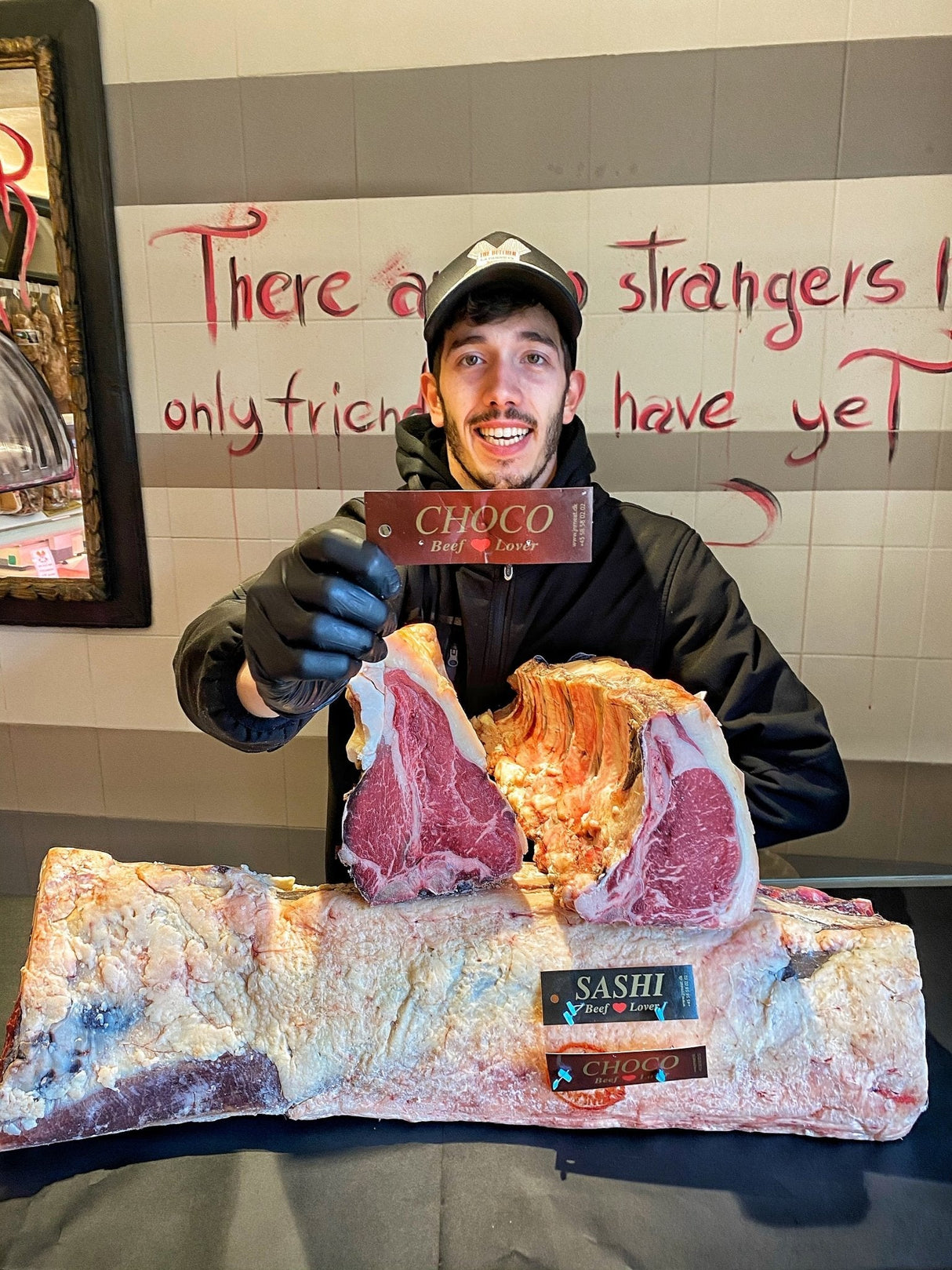 Fabio Callegari con il cartellino di autenticità della costata sashi choco e un bancale con questi tagli di carne