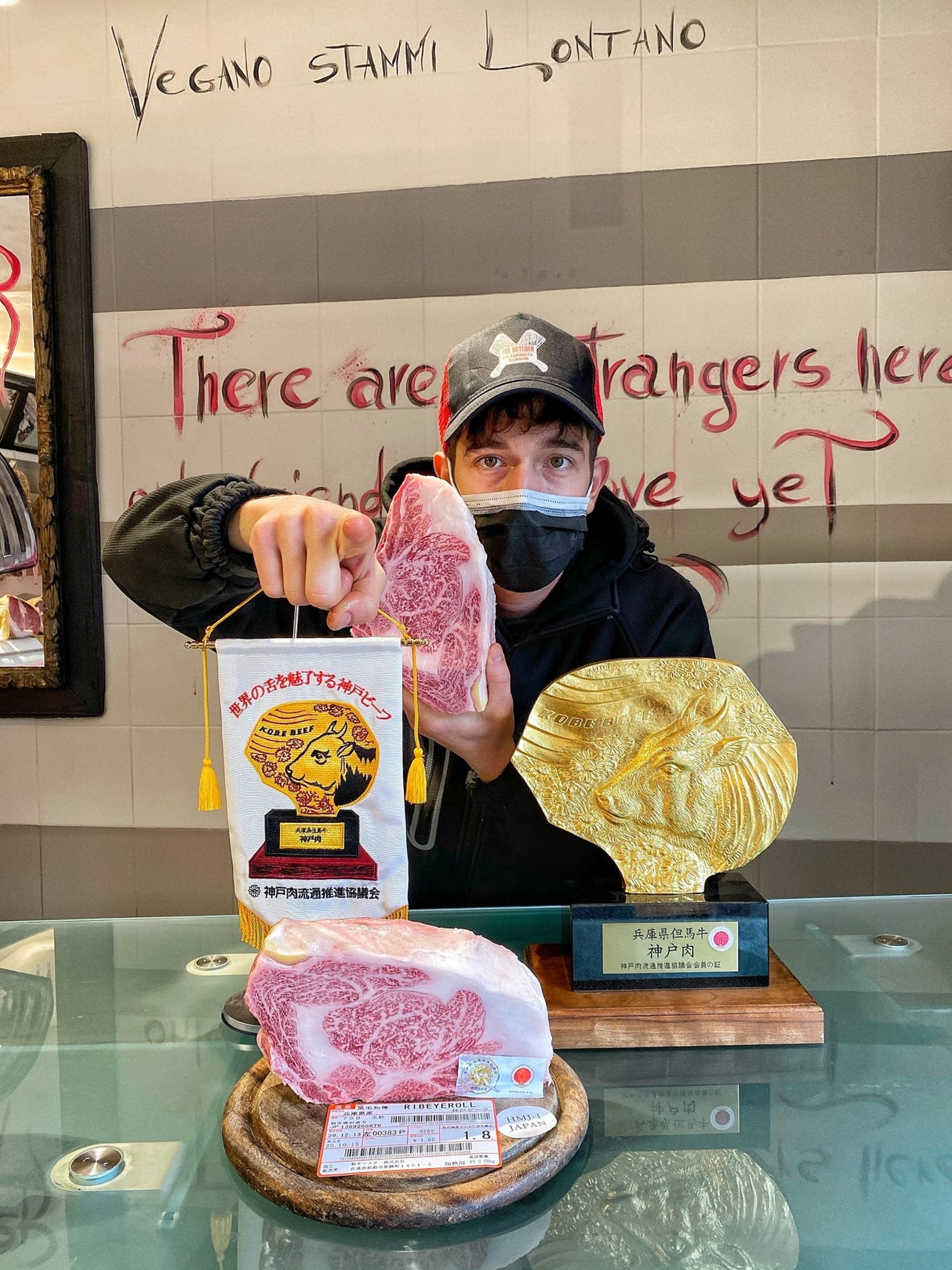 uomo con due premi per i rivenditori ufficiali di kobe e un tagliere di carne